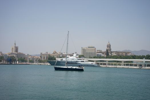 A blue boat sails in the ocean in Malaga, Spain, Europe on a summer day