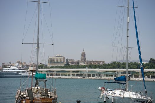 Boats with their sails down docking at the harbour in Malaga, Spain, Europe on a summer day with clear skies