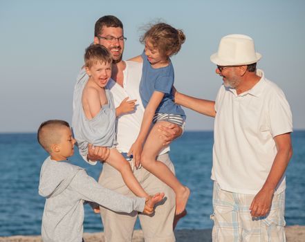 Group of five family members different generations - three kids, two boys and a girl, father and elderly male.