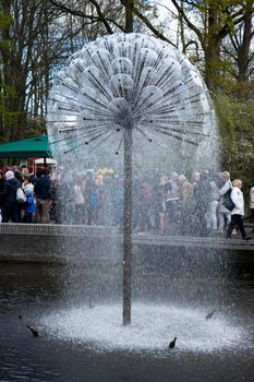 Lisse, Netherlands - April 17 : The Keukenhoff Tulip Gardens on April 17, 2016. Tourists gather near the water fountain  on a summer day