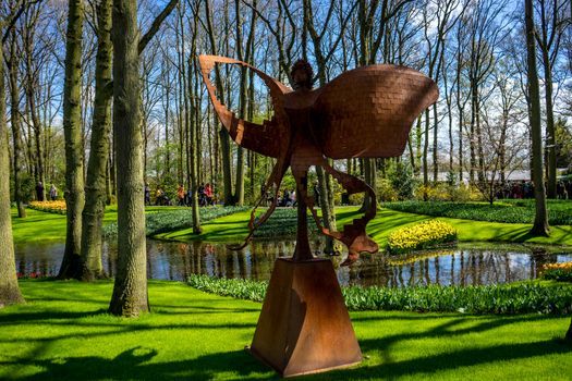 Lisse, Netherlands - April 17 : The Keukenhoff Tulip Gardens on April 17, 2016. Tourists gather near the fairy statue on a summer day