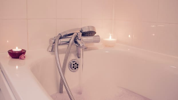 White and red candles in bathroom. Hot water and relax time at home.
