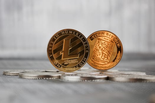 Cryptocurrency physical gold litecoin coin and gold titan bitcoin coin on silver money.