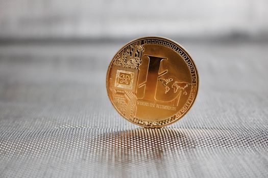Digital currency physical gold litecoin coin on silver background. Cryptocurrency.