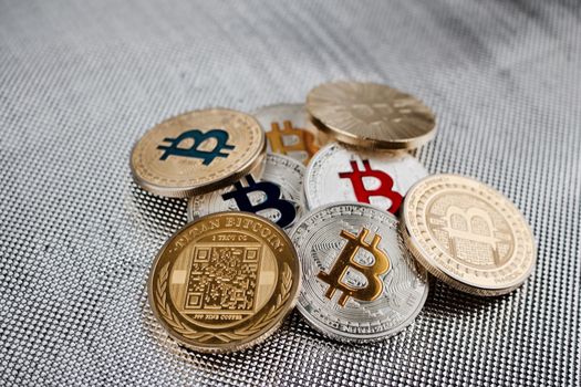 Digital currency physical gold and silver colorful bitcoins on silver background.
