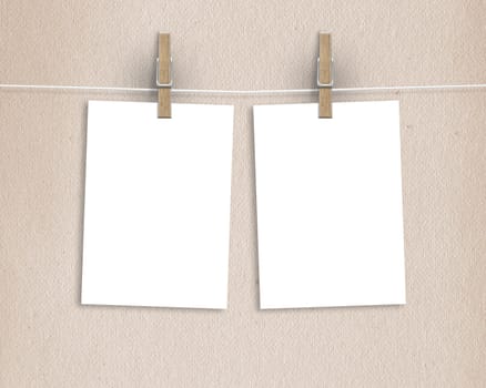 Paper cards hanging on a clothesline with clothespins on light background