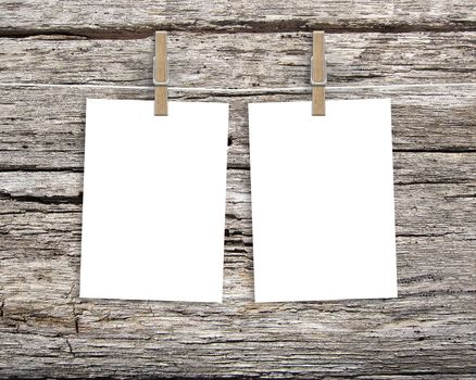 Paper cards hanging on a clothesline with clothespins on wood background