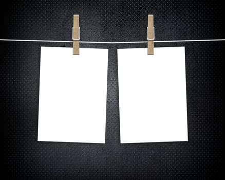 Paper cards hanging on a clothesline with clothespins on dark background
