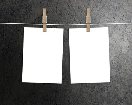 Paper cards hanging on a clothesline with clothespins on dark background