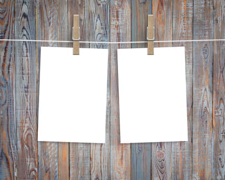 Paper cards hanging on a clothesline with clothespins on wood background
