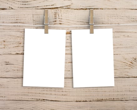 Paper cards hanging on a clothesline with clothespins on wood background