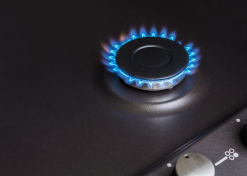 black kitchen gas stove burning burner close-up