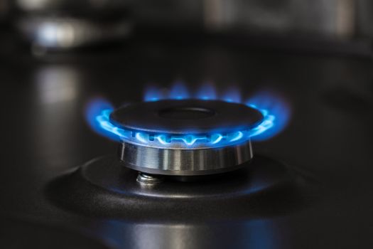 black kitchen gas stove burning burner close-up