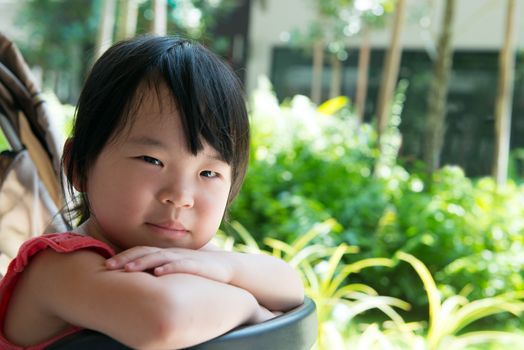 Little Asian child girl sitting in stroller