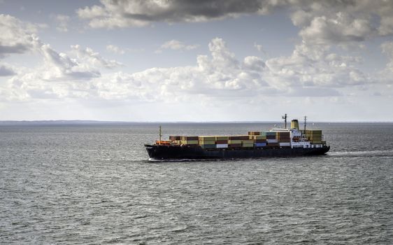 container ship on the sea with the bridge to denmark on the background