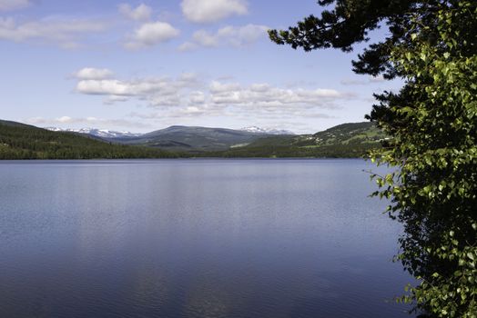 water in fjord norway with reflection of the mountains with snow in the lake