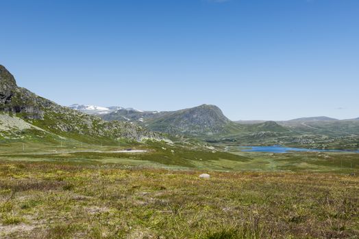 background of green hills and mountains in norway with blue sky background