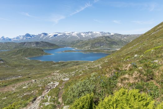 walking track in national park from bitihorn to stavtjedtet with lakes fjord and snow on the mountains