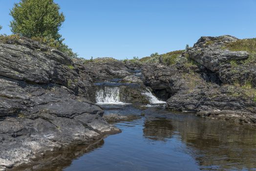 waterfall and rocks on the toll way in norway near Beitostolen