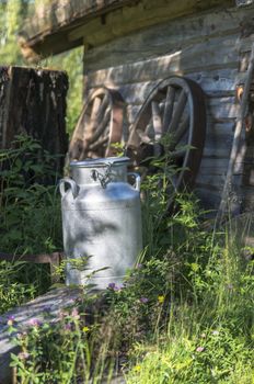 old milk churn in natural environment in fron of old wooden house in norway