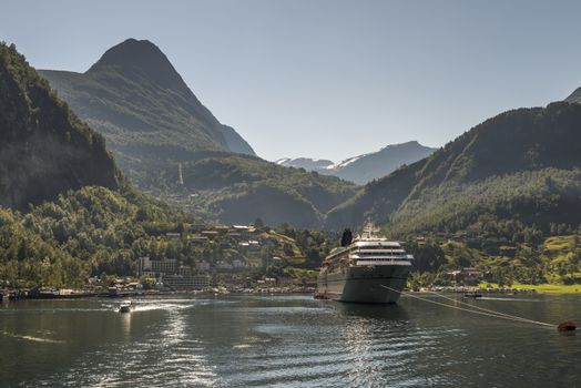 cruise ship on geirangerfjord in norway with snow on the hills in summer