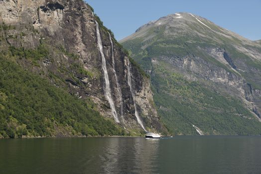 people on cruise boat at the famous geiranger fjord waterfalls in norway