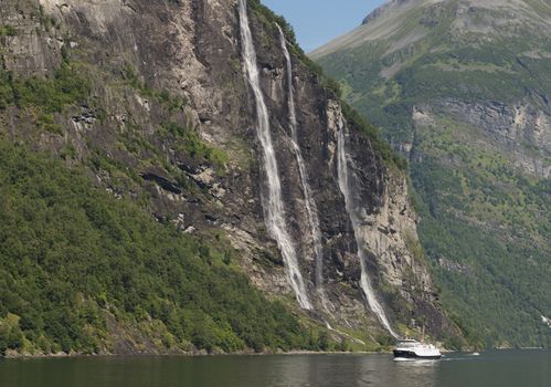 people on cruise boat at the famous geiranger fjord waterfalls in norway