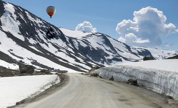 hot air balloon above the snow in summer on the gamle strynefjellsvegen one of the most beautifull auto roads in norway with snow in summer 
