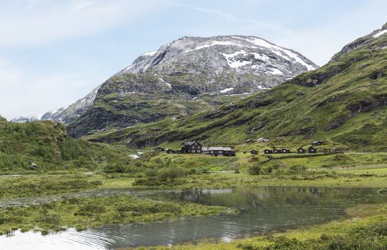houses in nature area Jostedalsbreen in summer with snow on the mountains