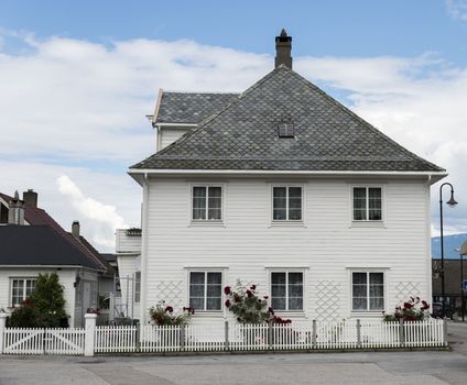 typical wooden houses in white in the village of Vik in Norway at the sognefjord