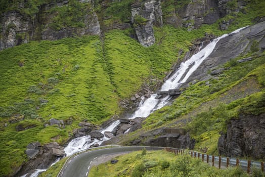 small waterfall in the area of likholefossen waterfall in norway with mountains as background