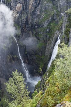 Voringfossen waterfall in norway seen from street level on sunny day 