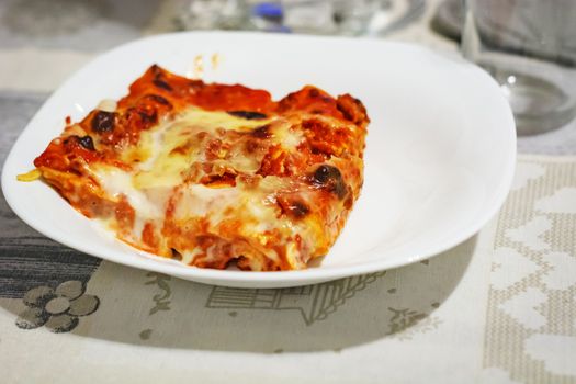 close-up view of a portion of lasagna served on a white plate