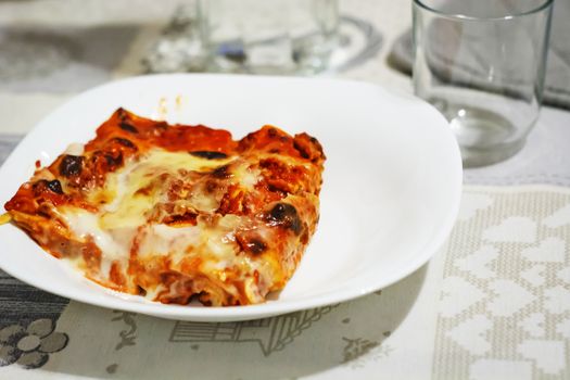 close-up view of a portion of lasagna served on a white plate