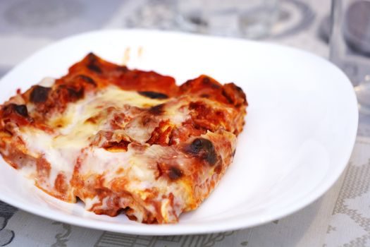 close-up view of a portion of lasagna served on a white plate