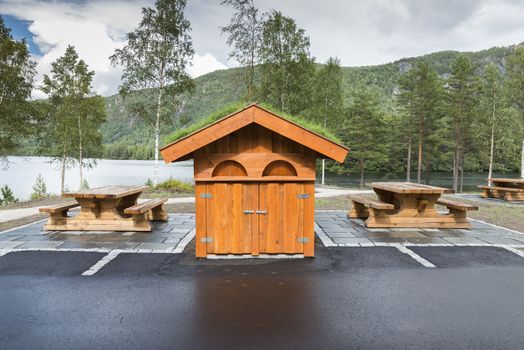 wooden toilet building and benches as a resting place on a fjord in Norway