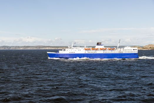 ferry with orange life boats from sweden to norway with sweden coast as background