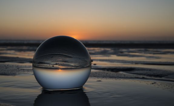 sunset on the beach captured in glass crystal sphere