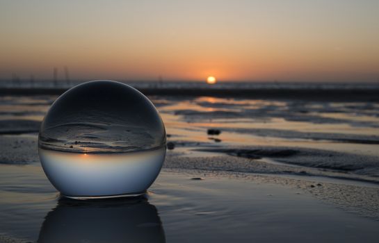sunset on the beach captured in glass crystal sphere