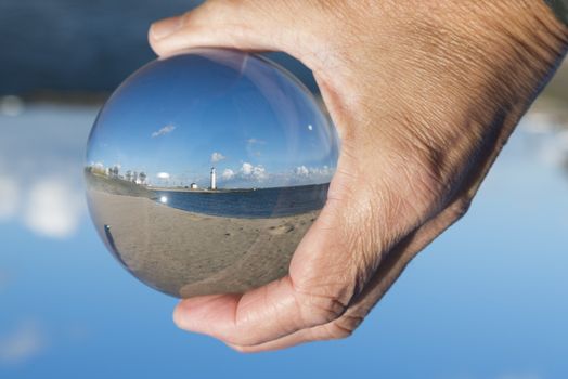 glass sphere with hellevoetsluis lighthouse from the beach