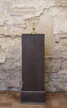 old religious menorah with ancient wall