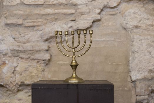 old religious menorah with ancient wall