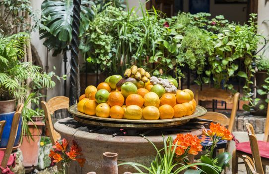 table with table with fresh fruit like oranges and bananas with table and chairs around