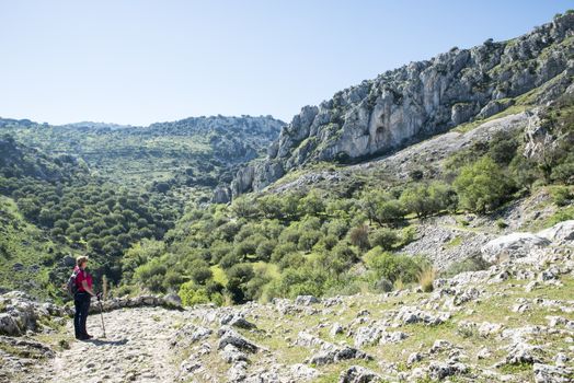 A mature woman busy on a mountain walk with backpack in the spanish part called andalusia near cordoba