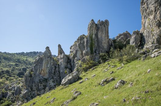 rocks and blue sky in andalusia with green grass landscape