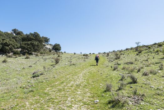 A mature woman busy on a mountain walk with backpack in the spanish part called andalusia near cordoba