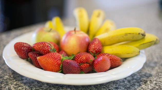 strawberries and banana with two appels on food plate