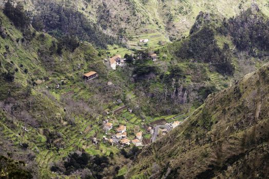 mountains and nature of Madeira island near Rabacal with houses and hairpin bend roads