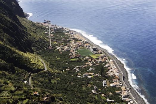 high mountains and the small road with hairpin above the small village Paul de mar with tennis court and coastline