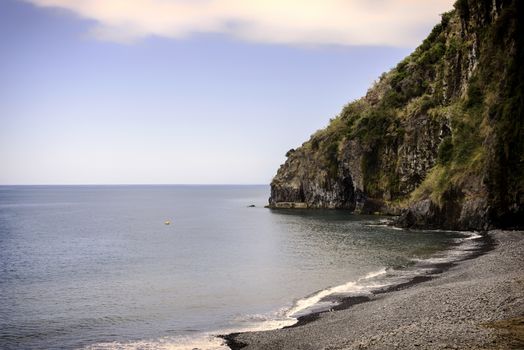madeira coastline with ocean and rocks with calm sea and rocky beack